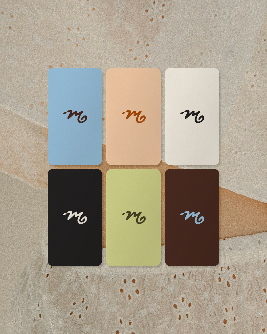 Six rectangular cards with Yin-Yang symbols in different colors arranged in two rows on a textured surface. The colors from left to right are blue, peach, white, black, light green, and dark red.