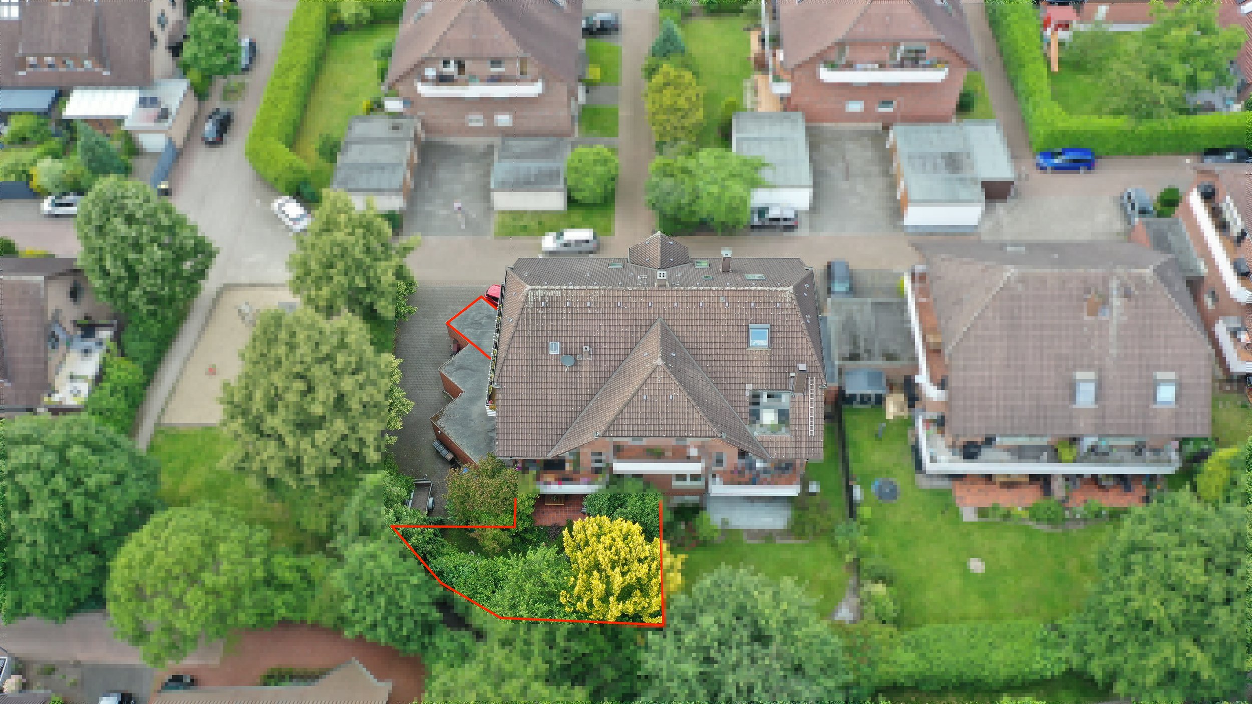Luftaufnahme eines Hauses mit umgebenem Garten und Bäumen, einigen eingefriedeten Bereichen und Nachbarhäusern in einem Wohngebiet.