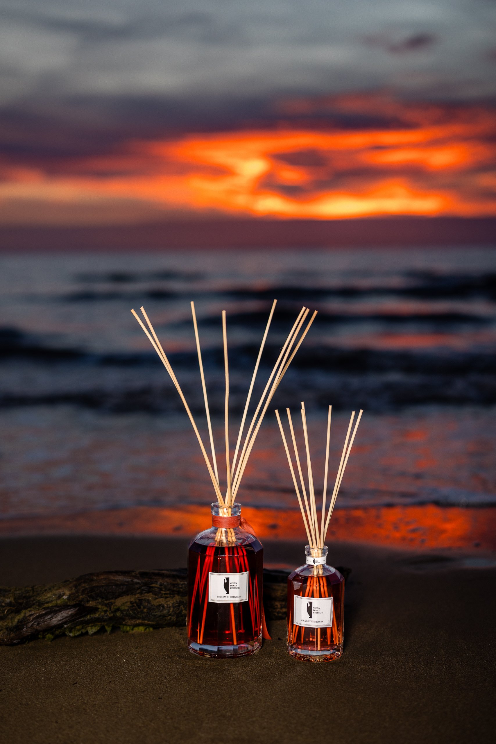 Costa degli Etruschi Profumi – Alba Mediterranea fragrance diffusers on the Tuscan beach at sunset, luxury home perfumes inspired by the Mediterranean.