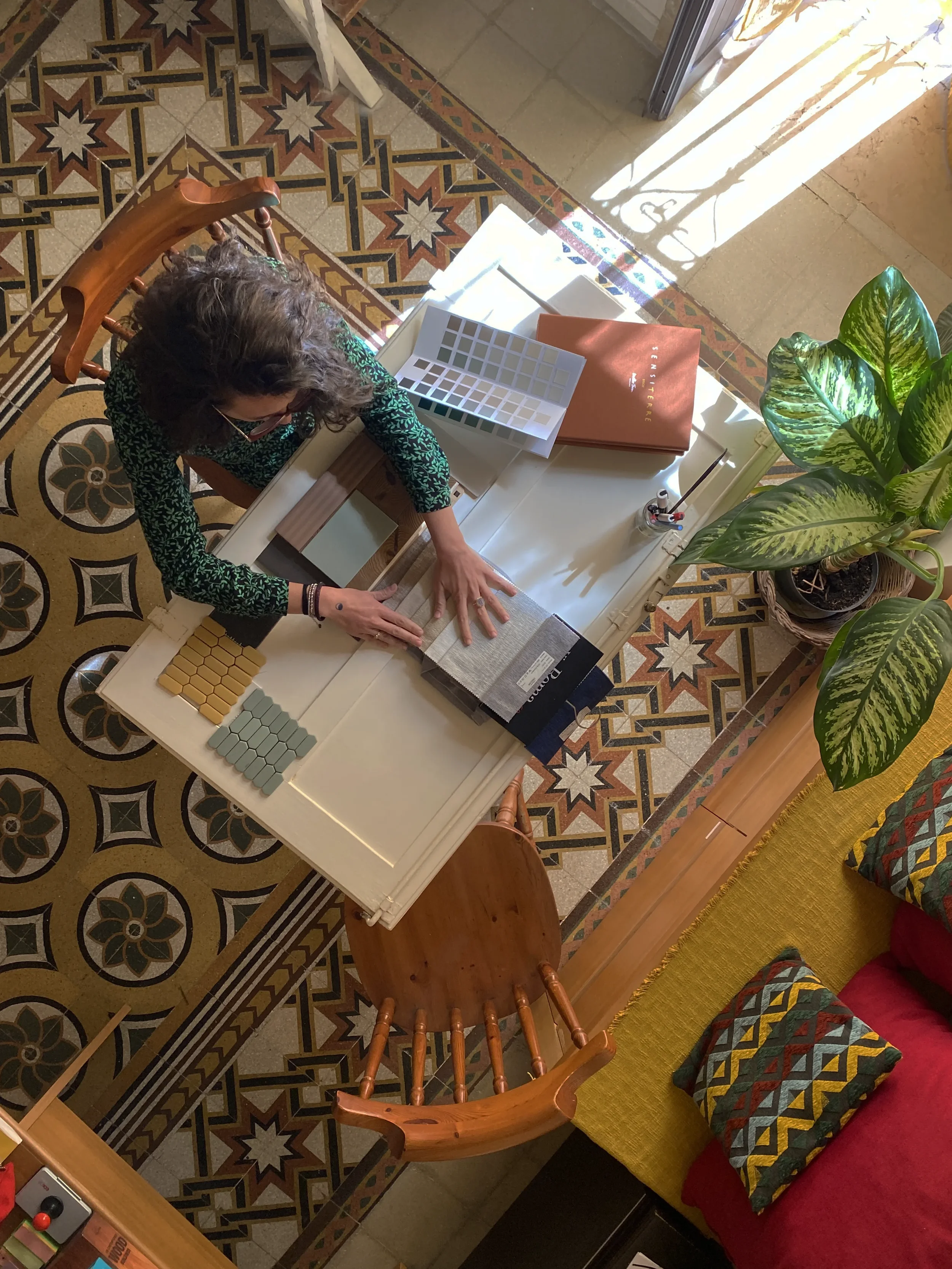 Interior designer selecting materials and color swatches on a historic Salento cementine floor by Pourriproject atelier