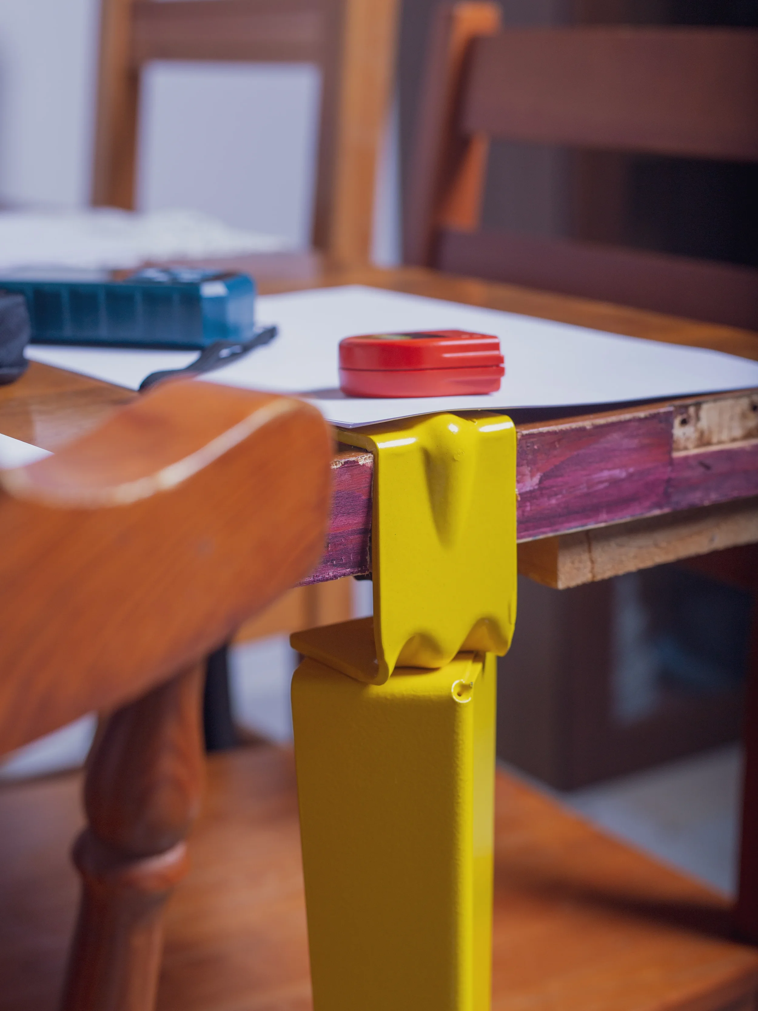 Bespoke table detail featuring reclaimed wood and yellow industrial metal leg by Pourriproject Atelier