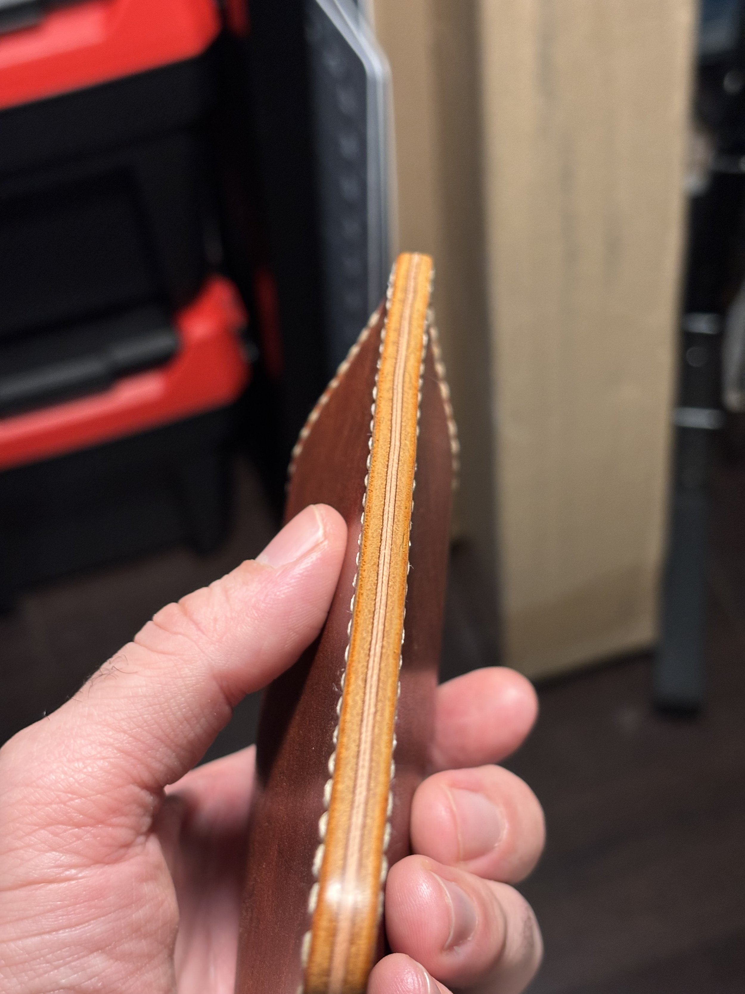 Side view of a handmade Horween Dublin leather card case showing the burnished edges and hand stitching.