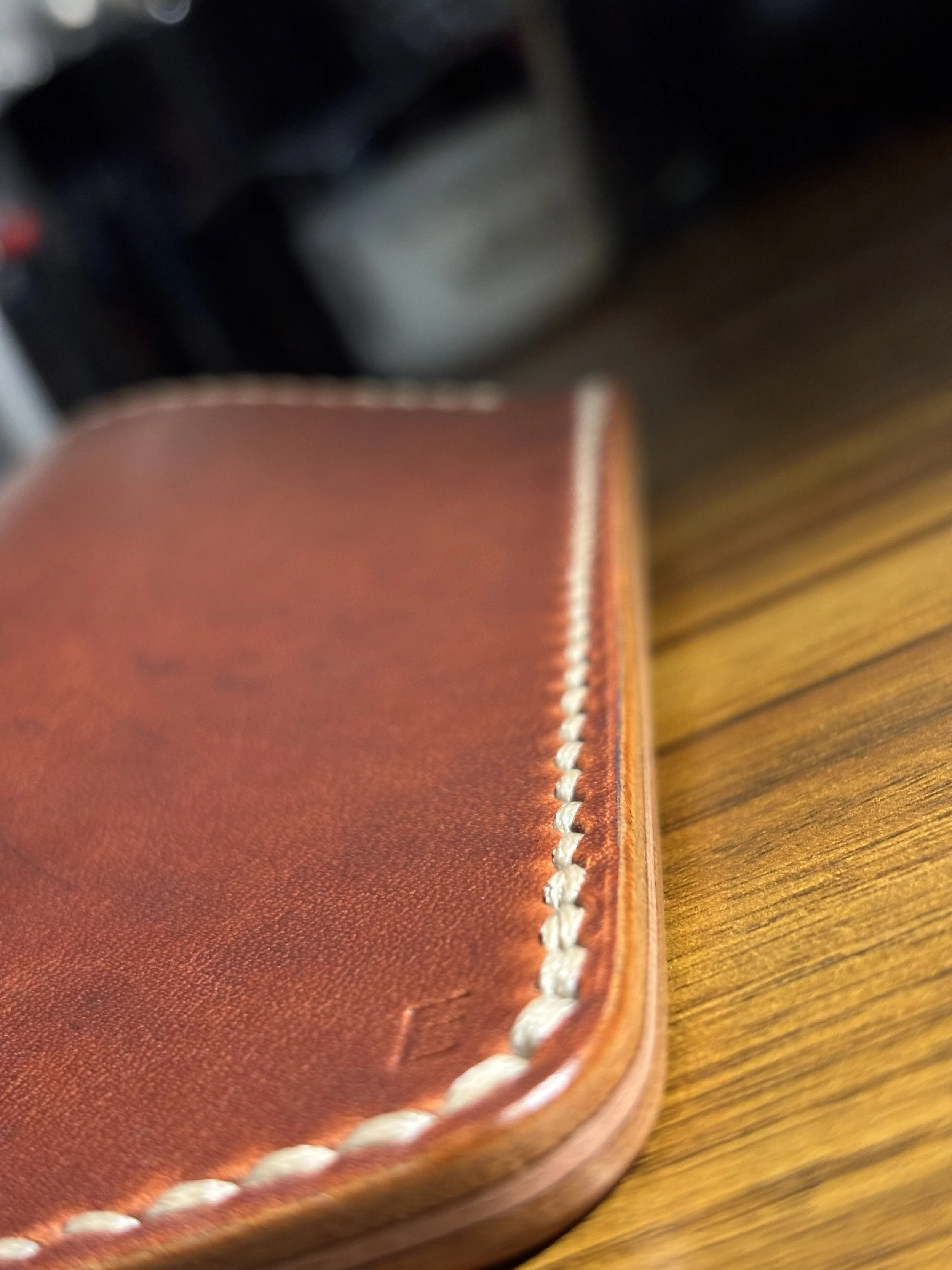 Hand saddle stitching, decorative crease, and hand-burnished edge detail on The Drifter Horween Dublin leather glasses sleeve.