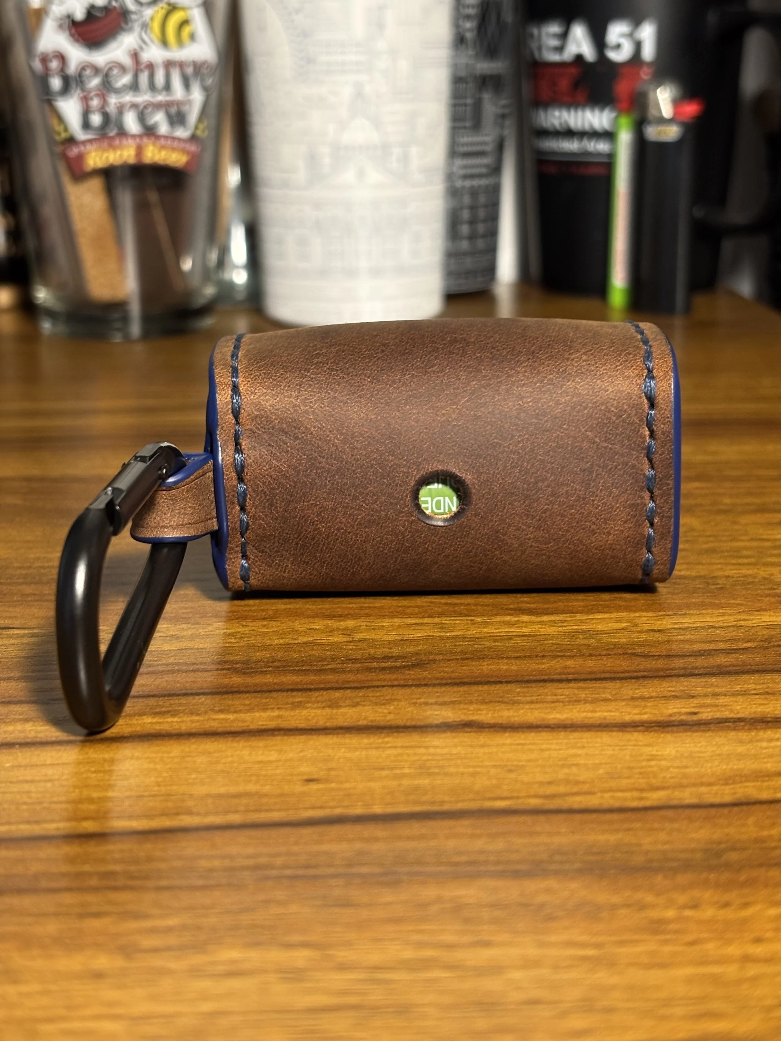 Back view of brown leather dog waste bag holder with carabiner attachment.