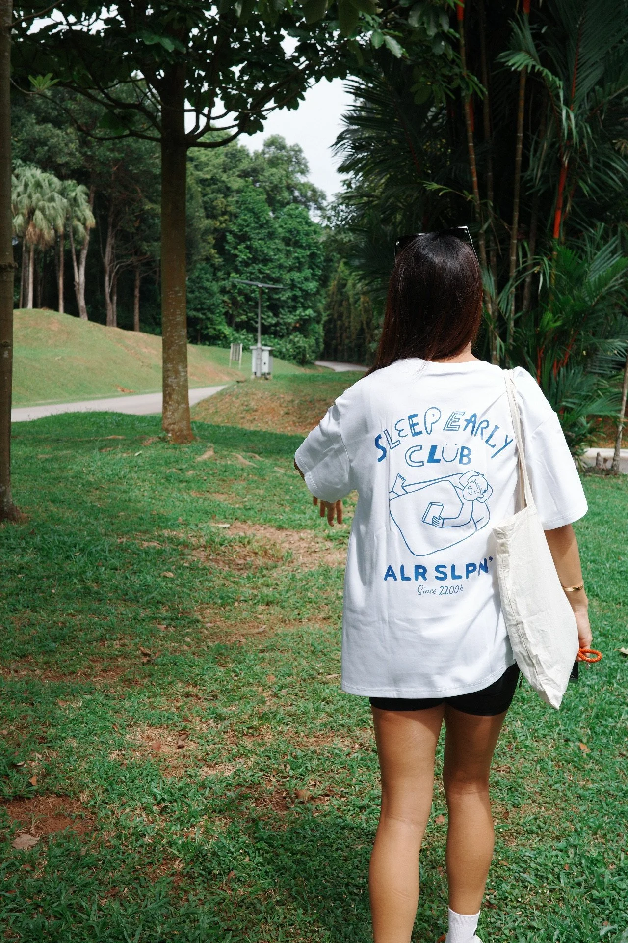 Back view of a white Sleep Early Club graphic t-shirt with bold blue graphics, unisex casual streetwear tee