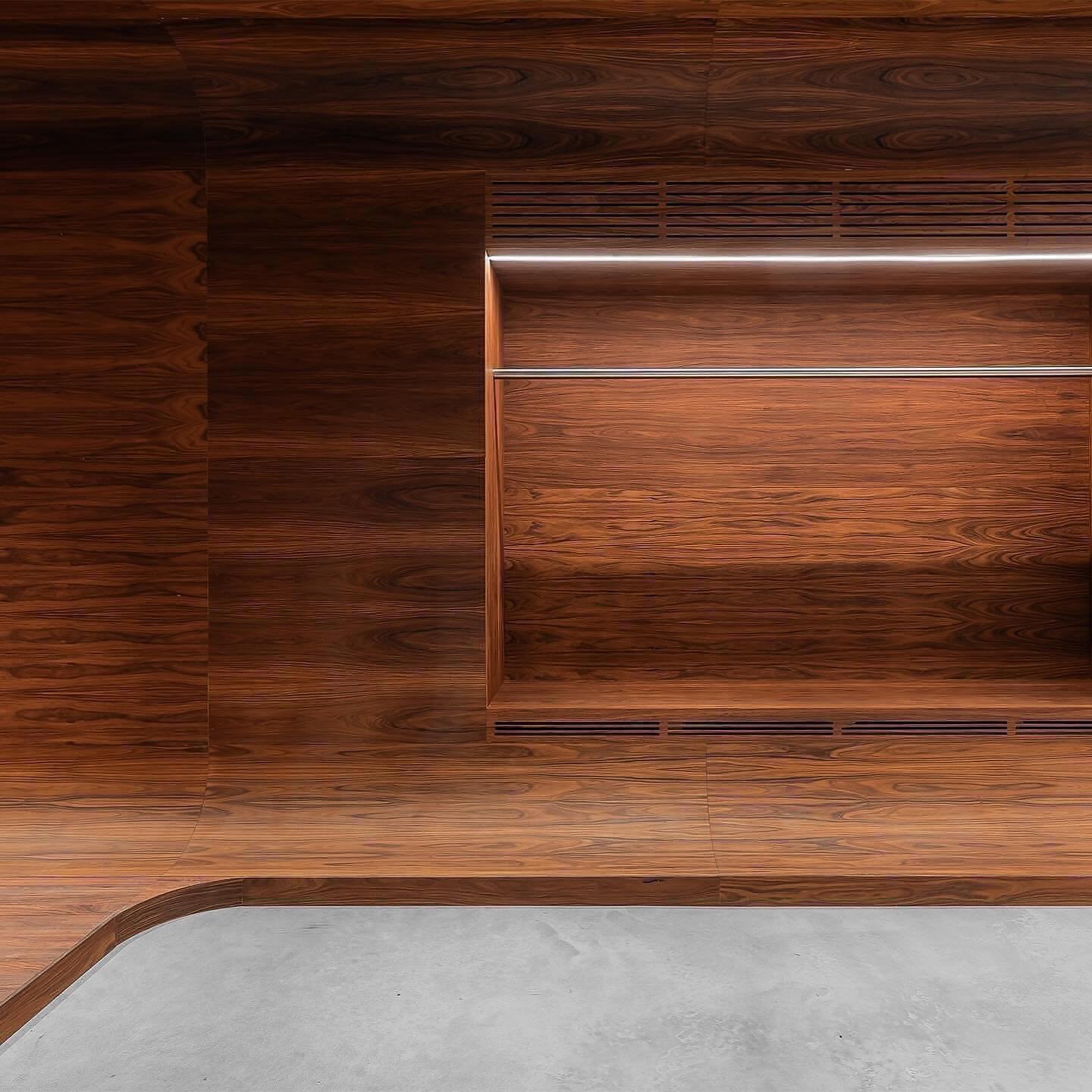 Mur en bois avec étagères métalliques dans une pièce moderne.