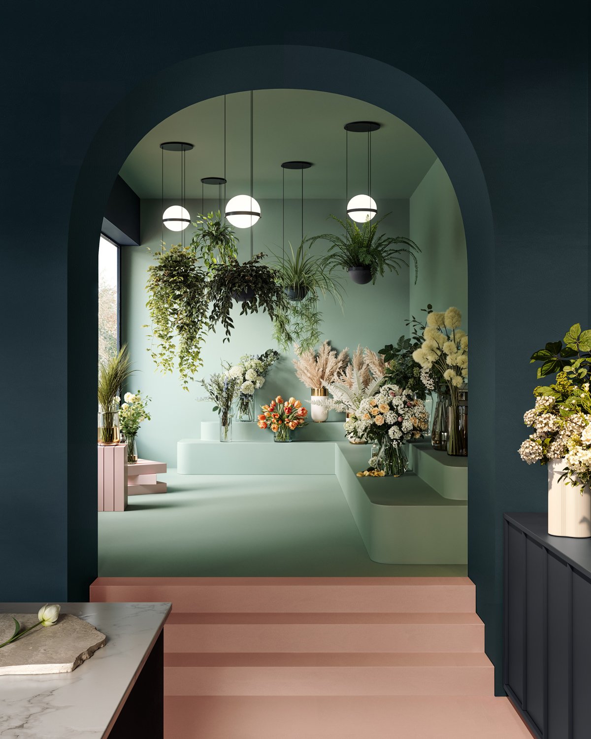 Une pièce décorée avec de nombreuses fleurs dans des vases, sous un plafond avec trois lampes rondes suspendues, vue à travers une arche blue, avec un escalier rose menant à un espace vert clair