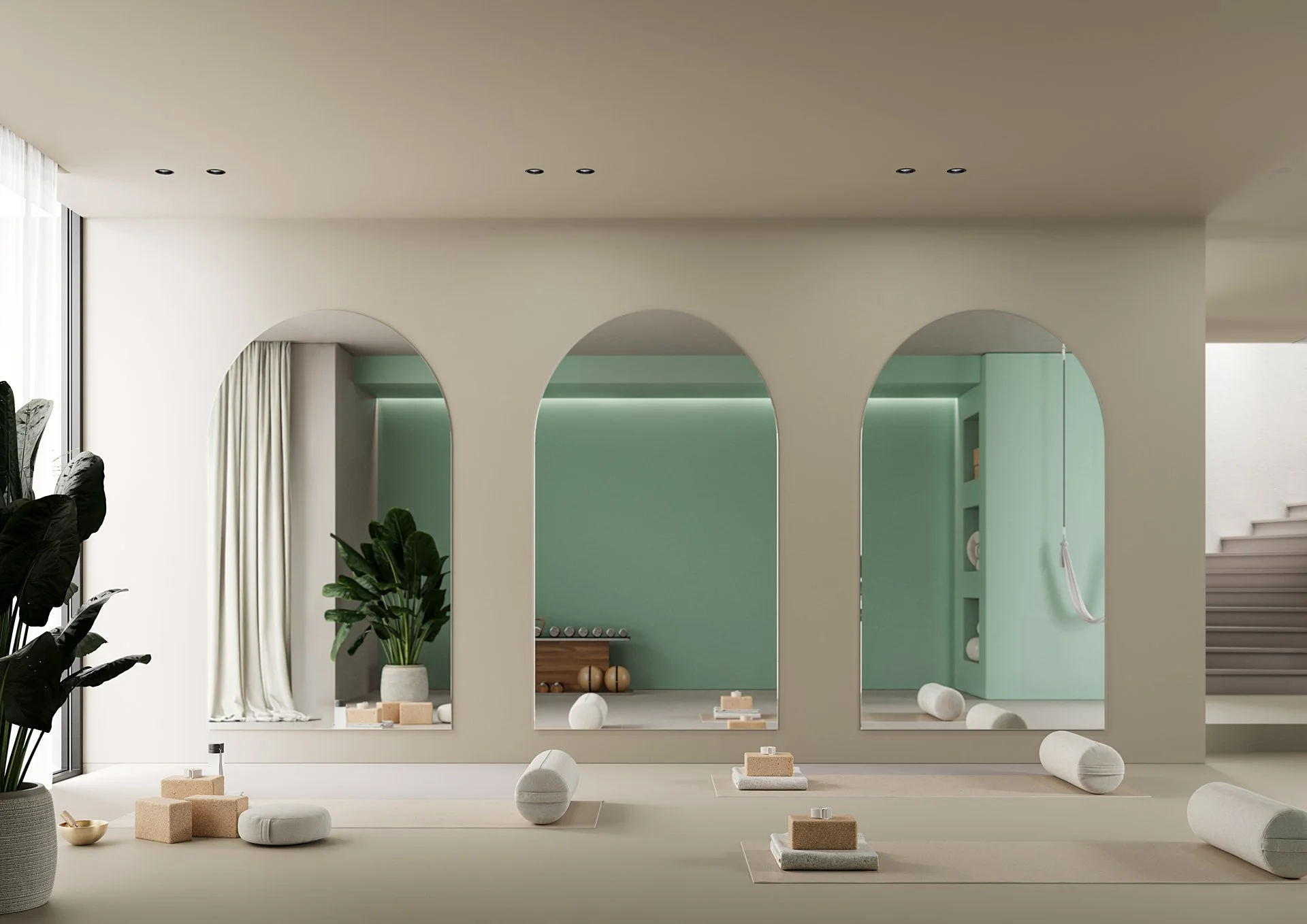 Salle de yoga élégante avec tapis, blocs et rouleaux de foam, murs pastel vert et crème, grandes arches, plantes vertes, et escalier en arrière-plan.