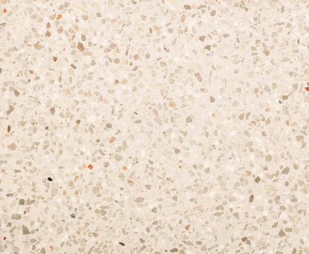Surface en pierre ou en terrazzo de couleur claire avec des petits fragments colorés