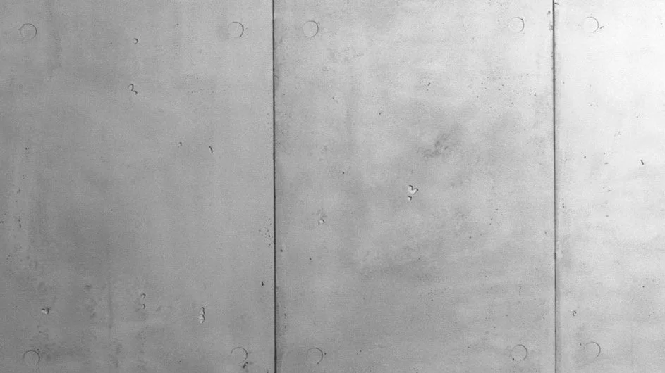 Surface en béton gris avec des joints de béton et de petites imperfections.