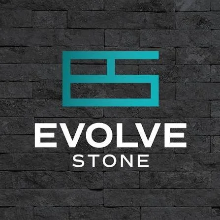 Logo for Evolve Stone featuring a stylized 'ES' symbol on a dark brick wall background.