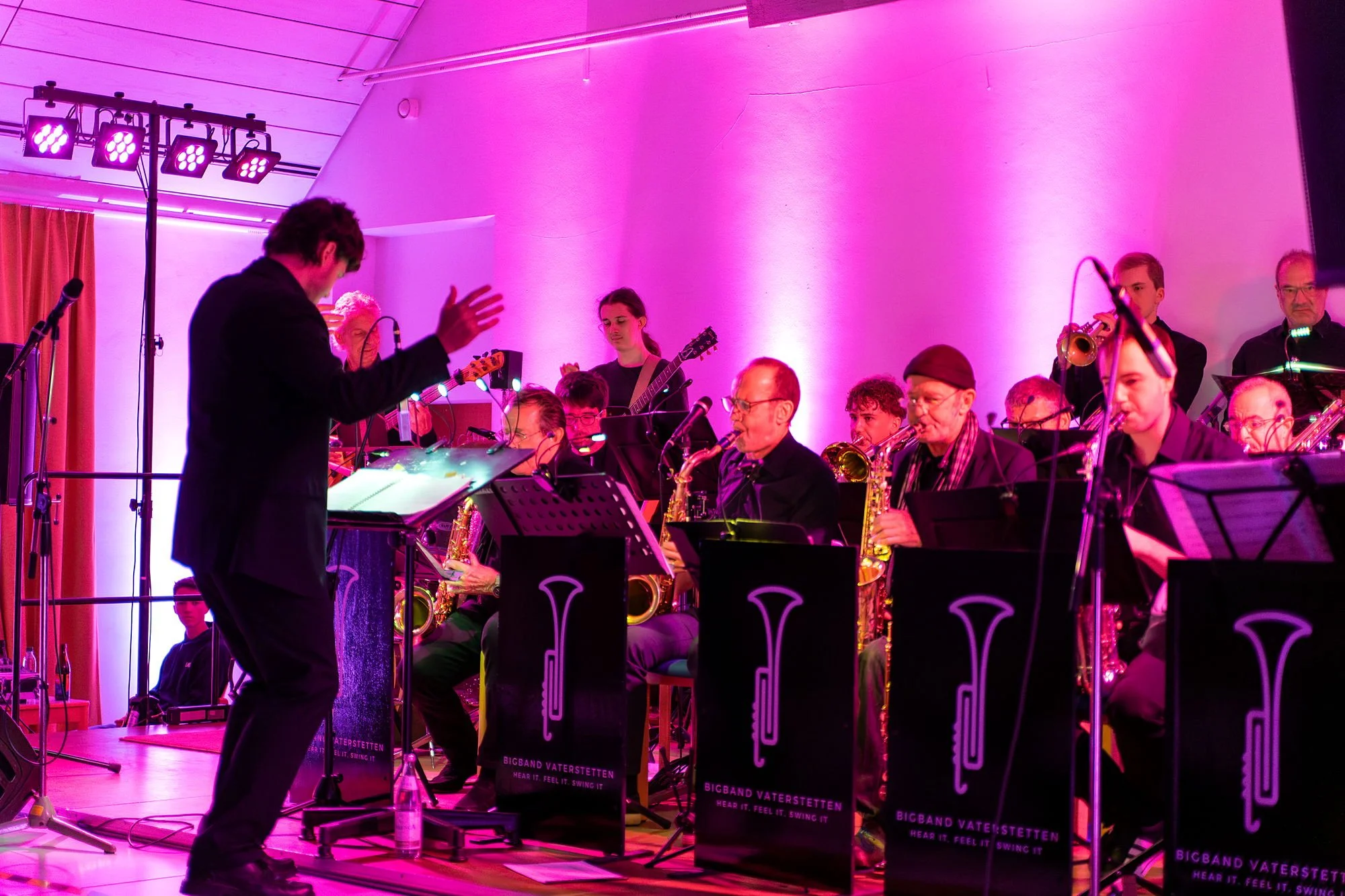 Nico dirigiert, ganze Band im magentafarbenen Licht. Der Einstieg.