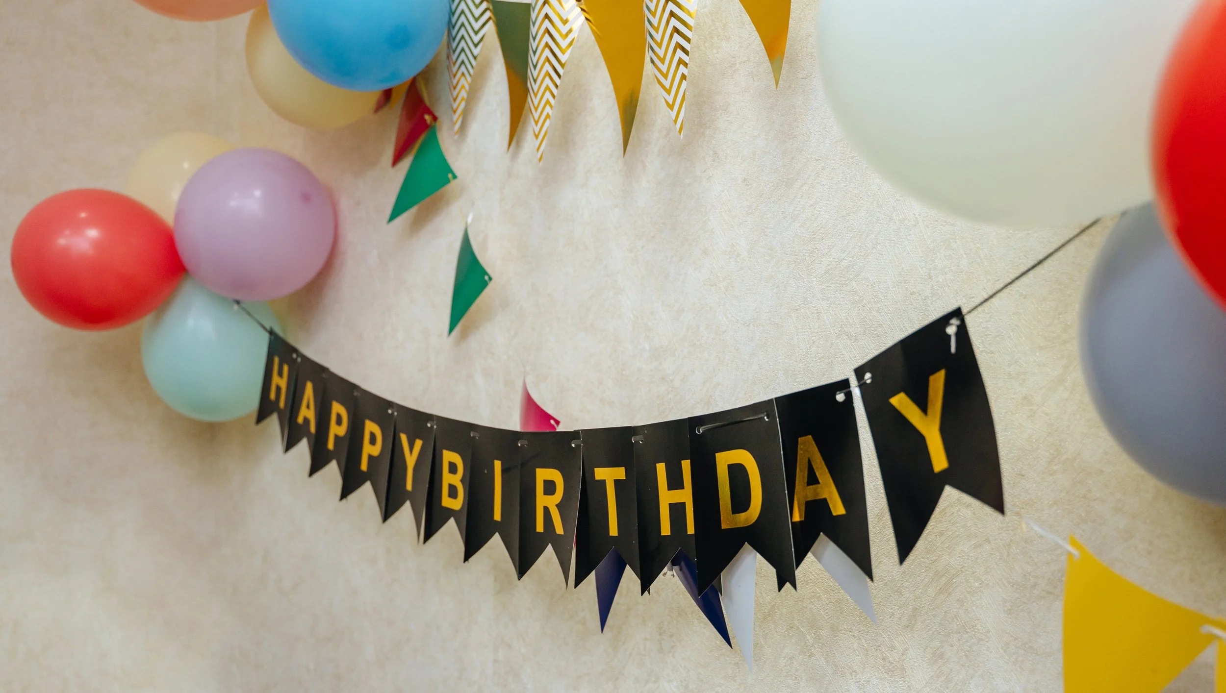An image of a banner with writing "happy birthday" and balloons