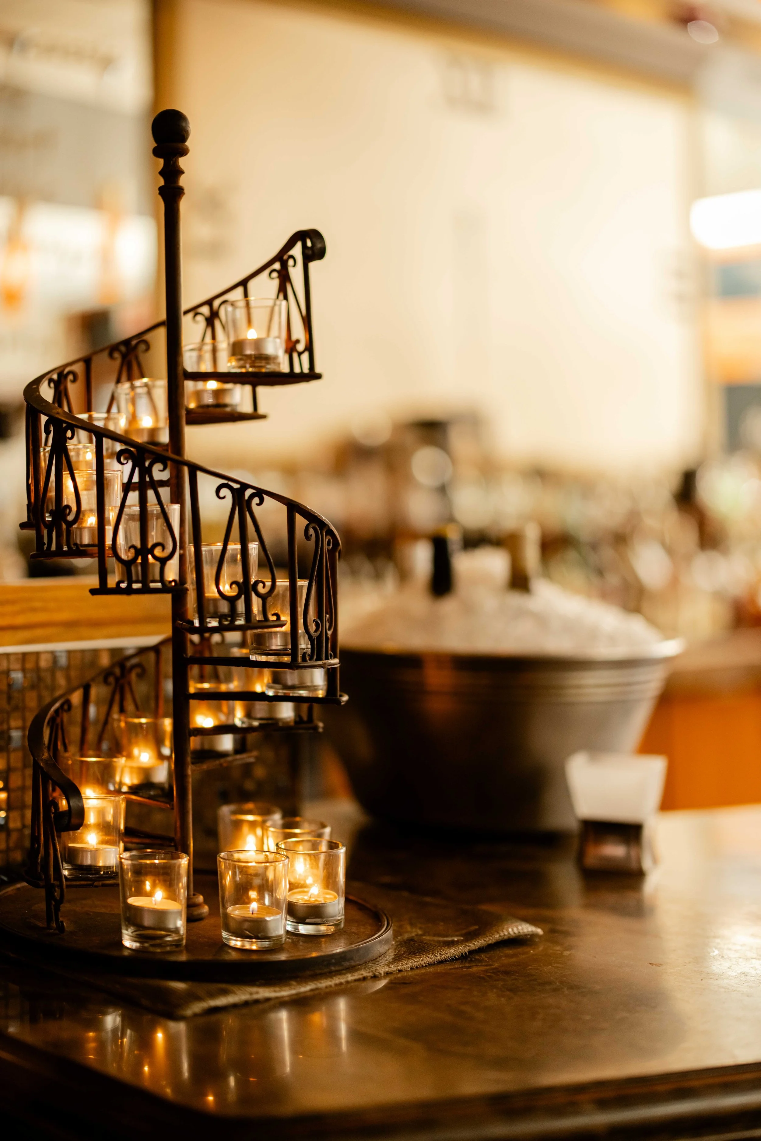 Decorative candle holder with multiple lit candles on a wooden table in a cozy, warmly lit interior.