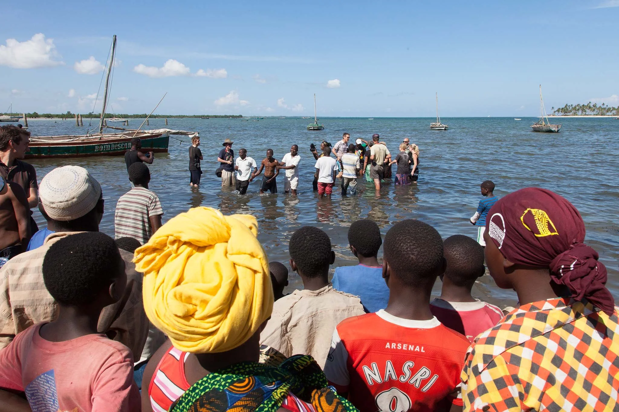 Onlookers at a fishing village watching another Iris baptism