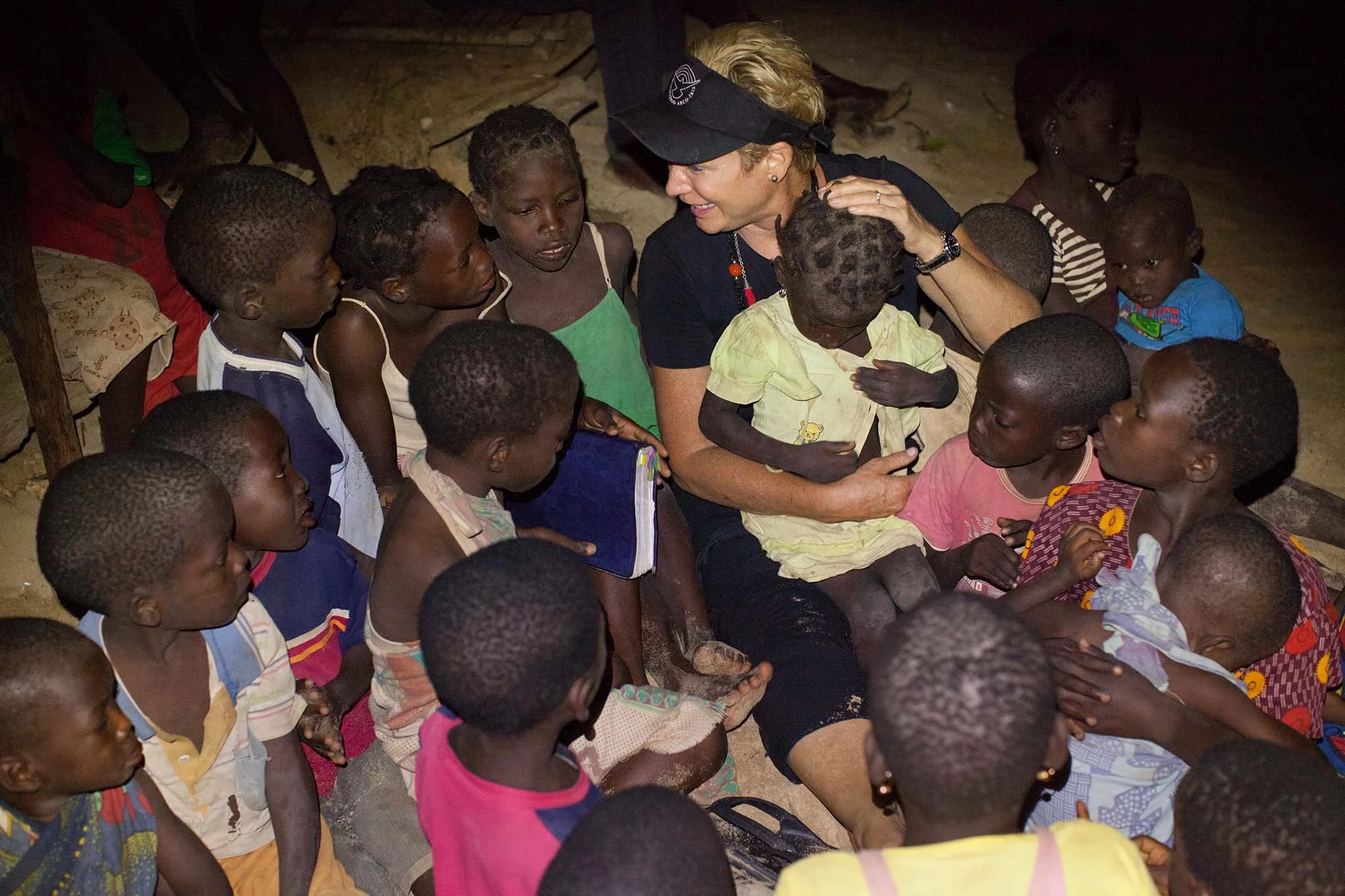 Heidi speaking to children in the night on a dark village beach