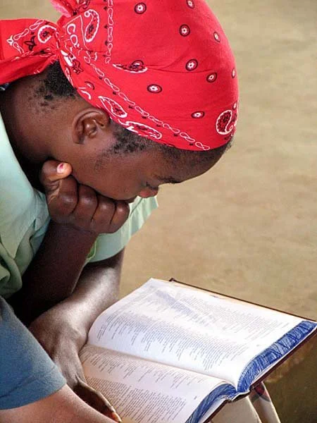 One of our children intently following the Sunday message in Scripture, a wonderful achievement after coming to us without education