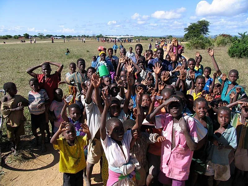 Children in Malawi excitedly following us from our plane to the meeting
