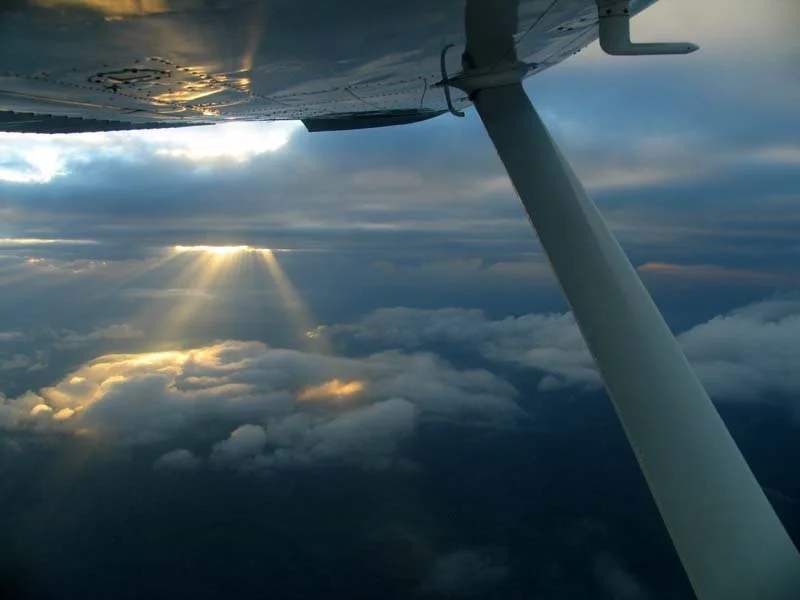 Sunlight breaking through clouds as we descend into Pemba on the northern coast of Mozambique