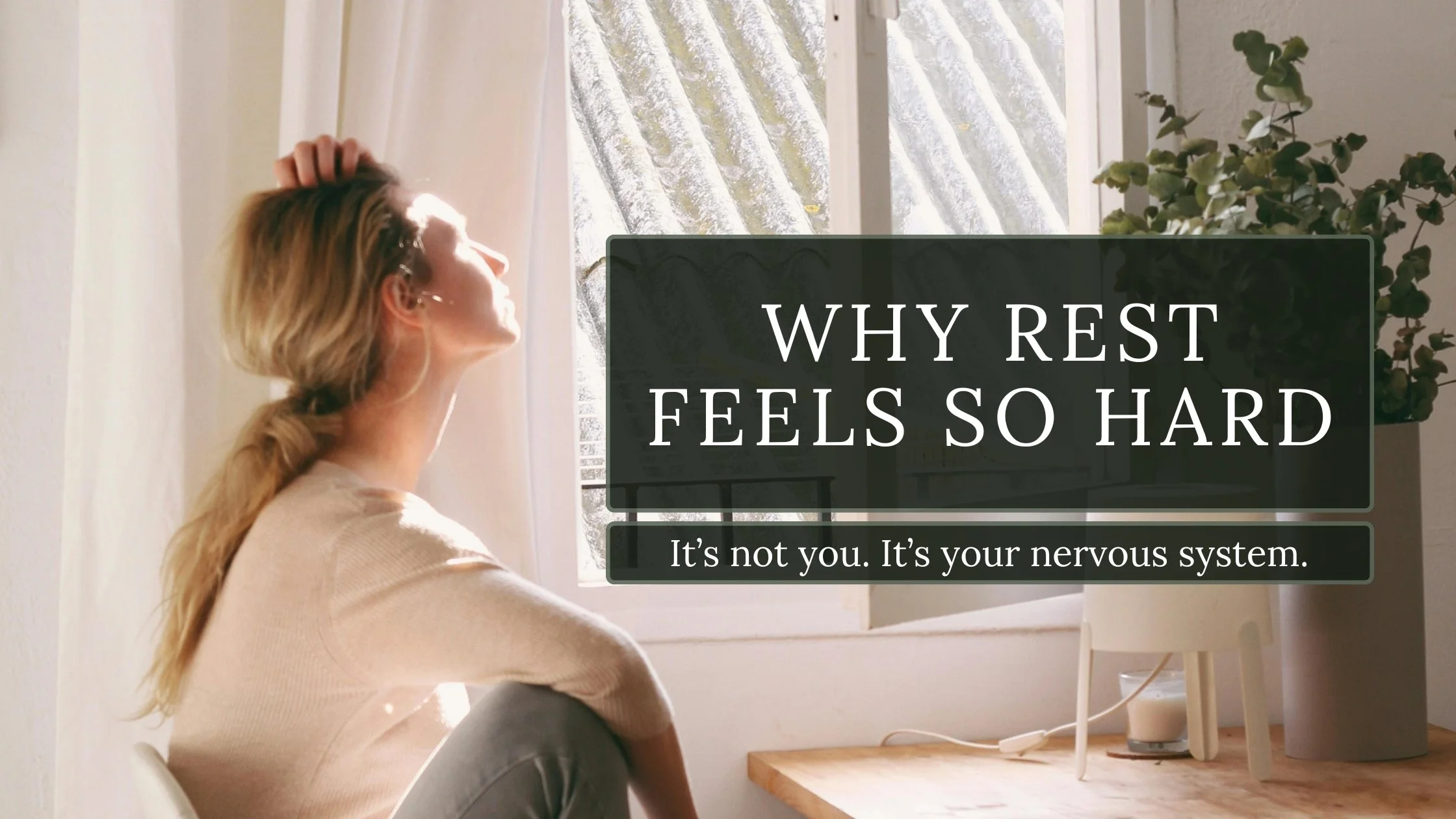 Woman sitting quietly in a chair by a window with soft natural light, reflecting on rest and nervous system regulation.