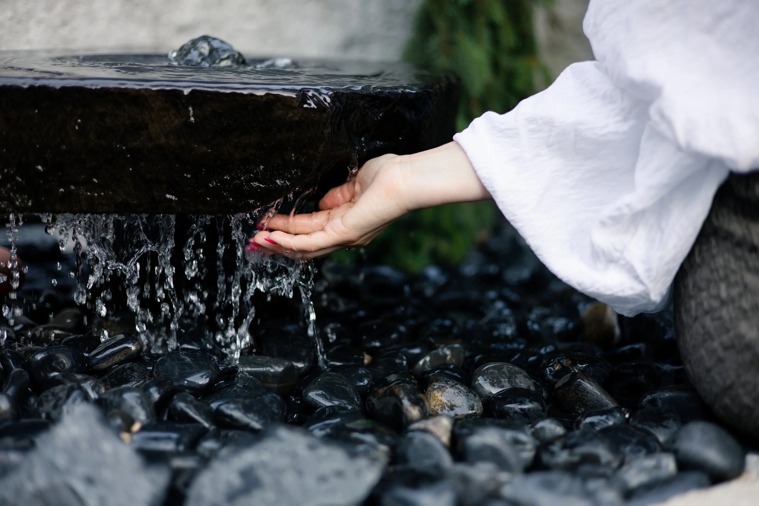 Hand gently touching flowing water