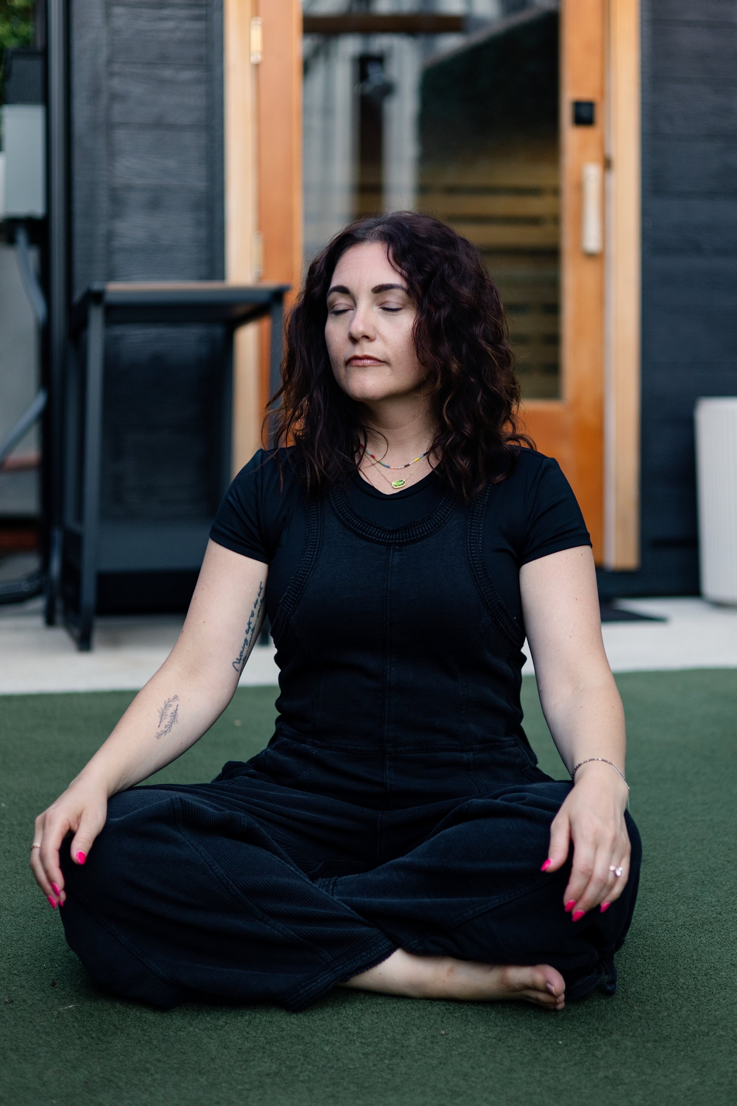 Mallory Tedrick seated outdoors in a grounding meditation practice