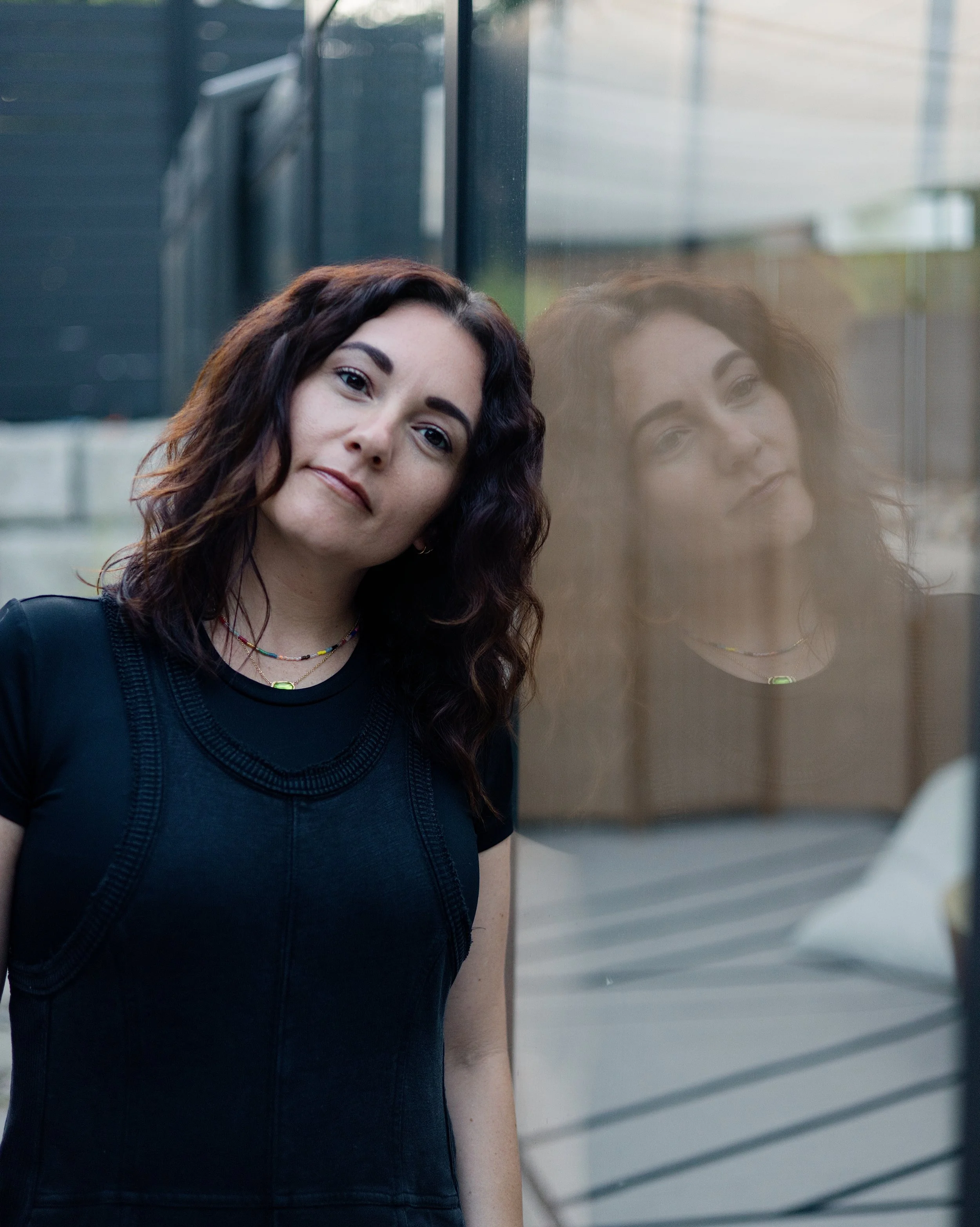 Mallory Tedrick leaning beside a reflective window