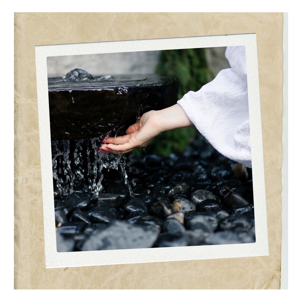 Hand gently touching flowing water