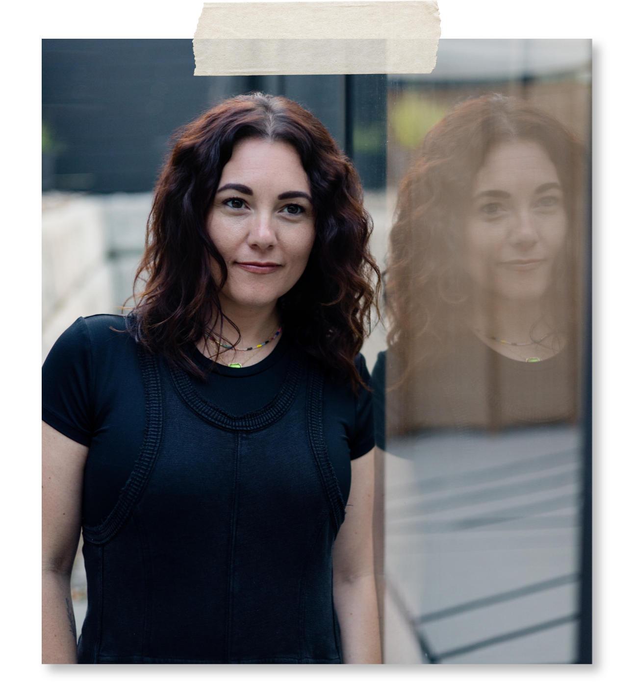 Mallory Tedrick standing beside a reflective window