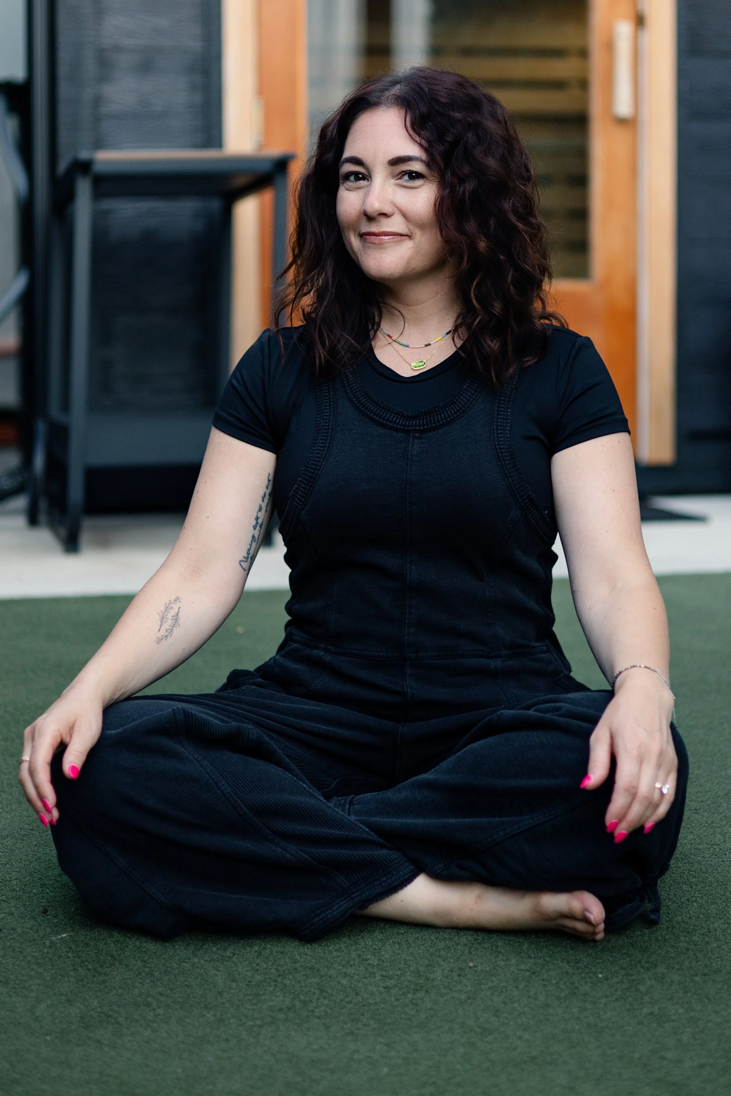 Mallory Tedrick seated cross-legged outdoors