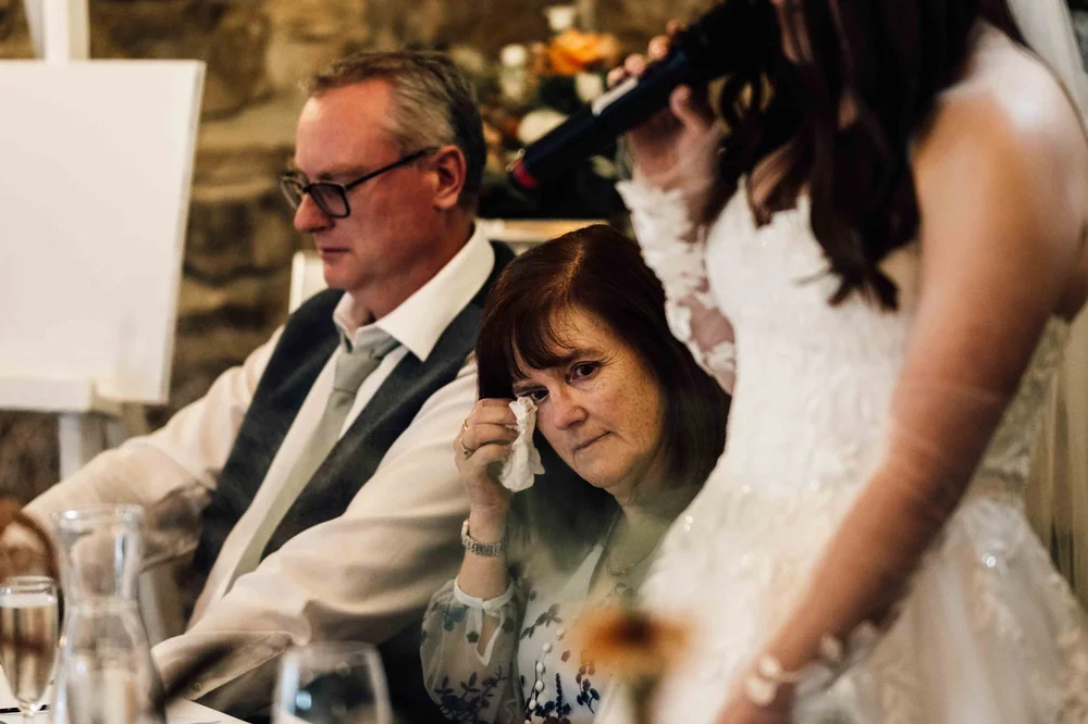 A wedding guest wiping away a happy tear
