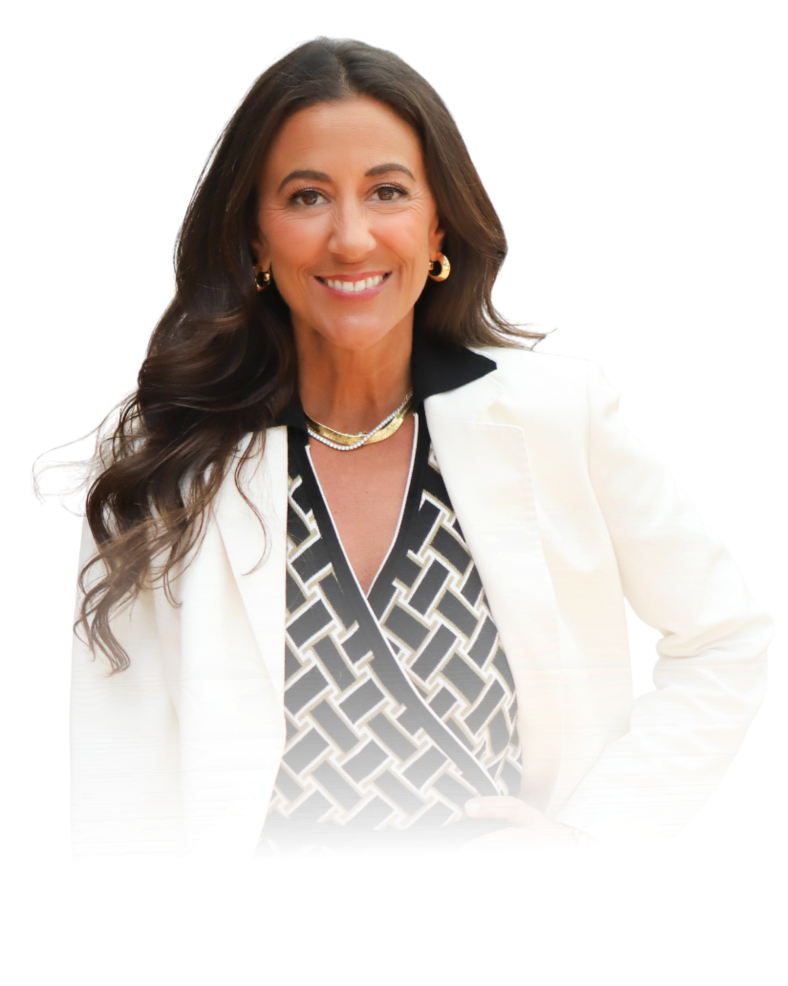 A woman with long wavy brown hair wearing a white blazer over a black and white patterned top, accessorized with gold jewelry, smiling at the camera.