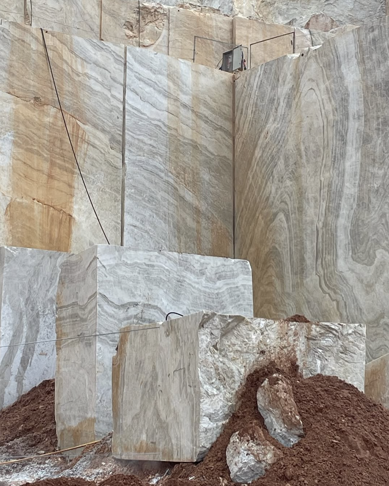 Large natural stone block being processed into individual slabs.