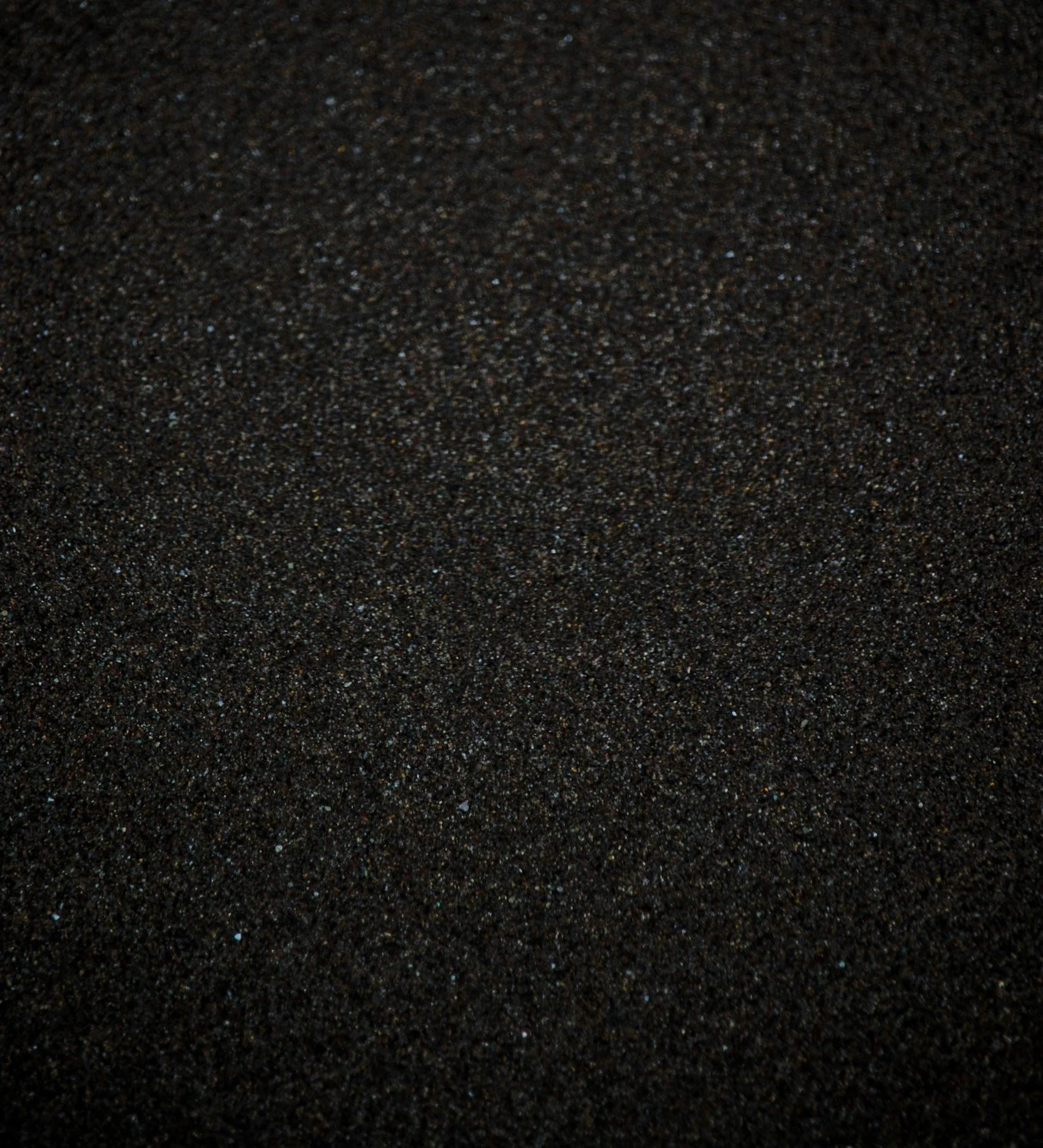 Close-up of black sand with tiny reflective particles