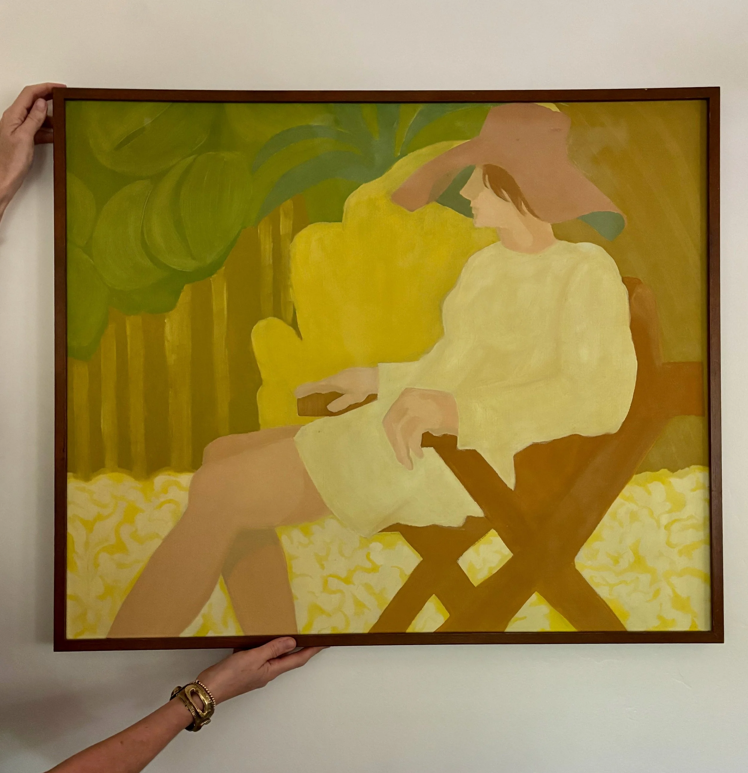 Painting of a woman sitting in a yellow chair, wearing a wide-brimmed hat and a light yellow dress, in a bright setting with green foliage in the background.