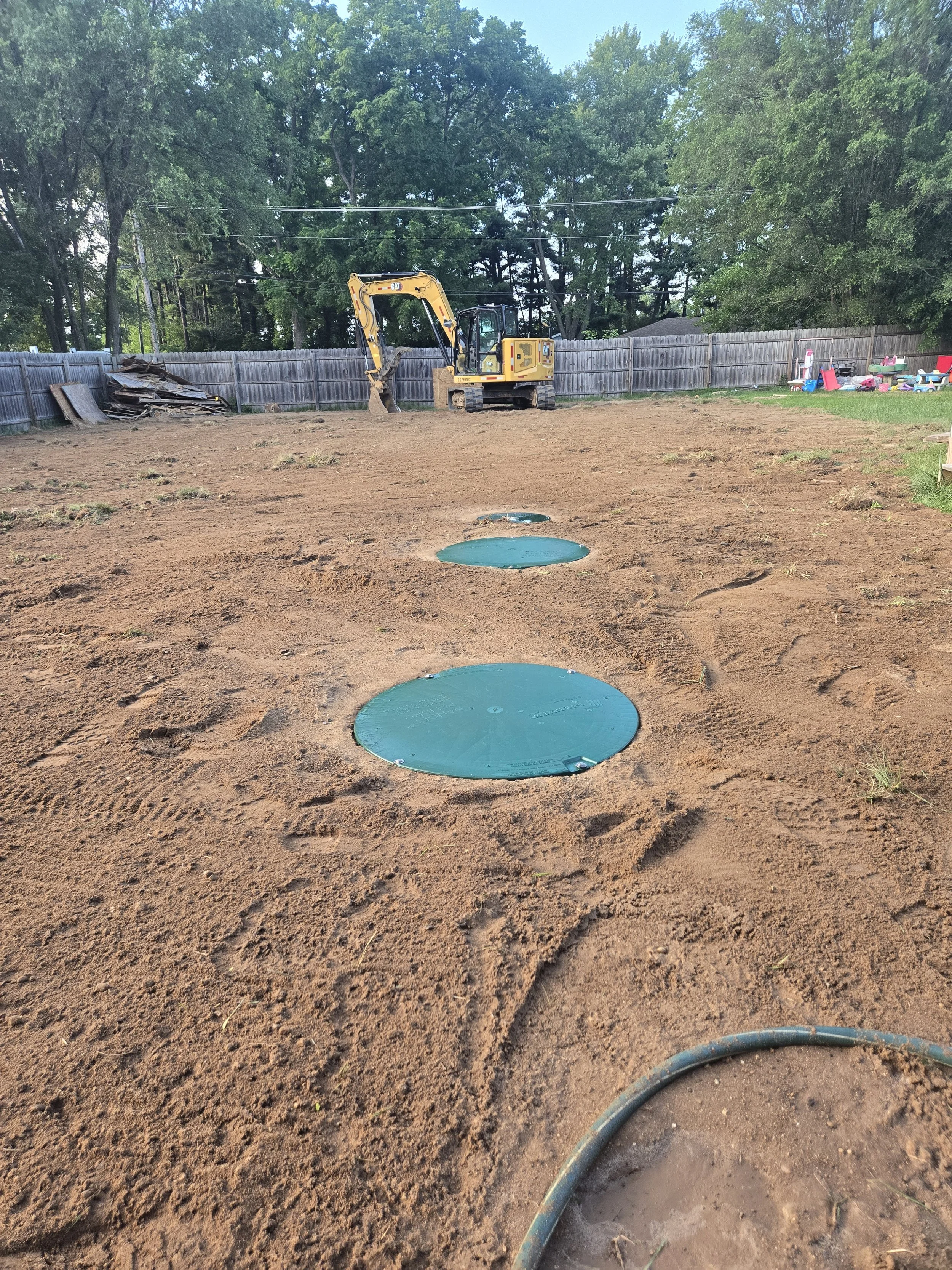 septic tank installation with access lids leveled to yard surface
