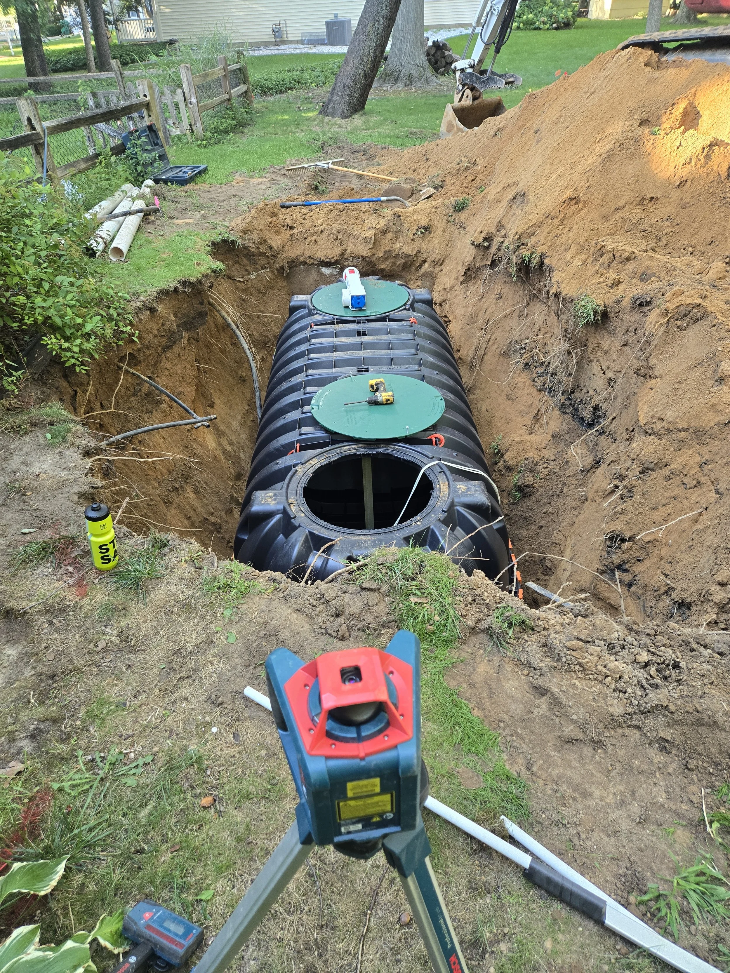 septic pipe installation with laser level alignment in trench