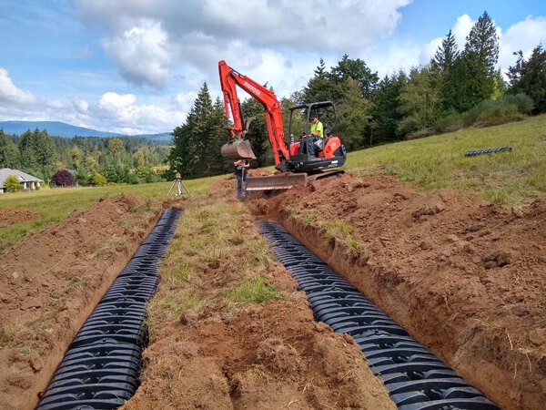 excavator placing chamber units during trench septic system installation
