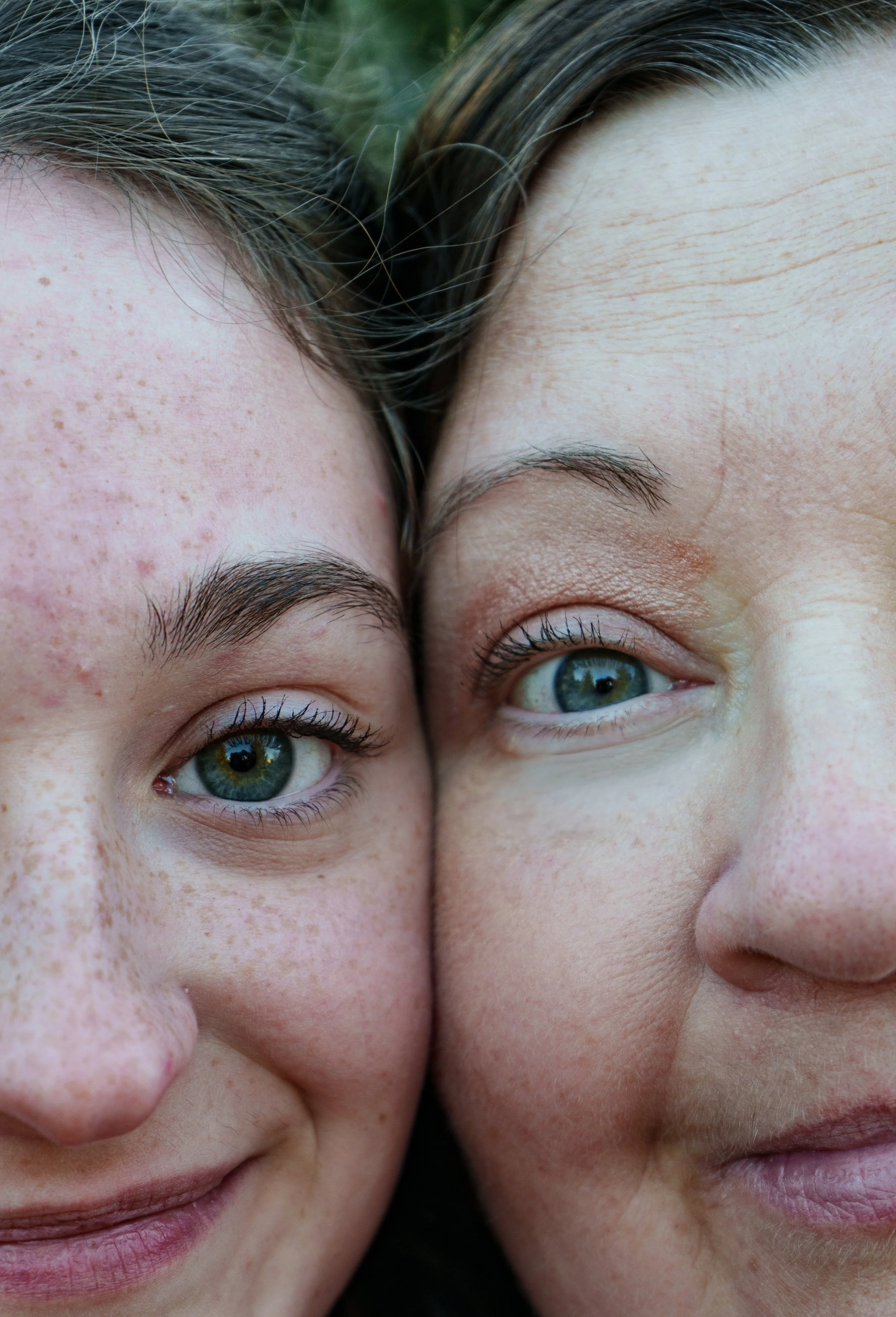 Close-up of two young women face-to-face, showing their eyes and part of their noses.