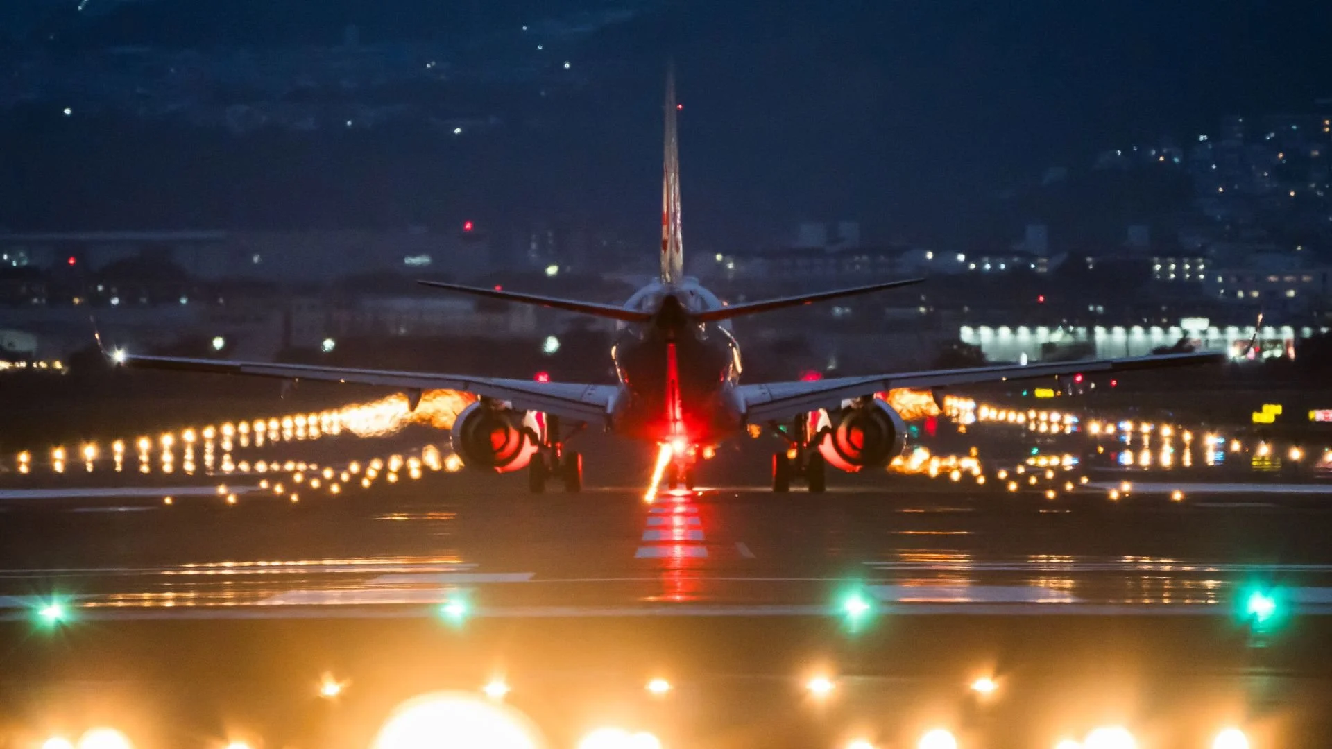 Airplane taking off on evening runway with illuminated lights