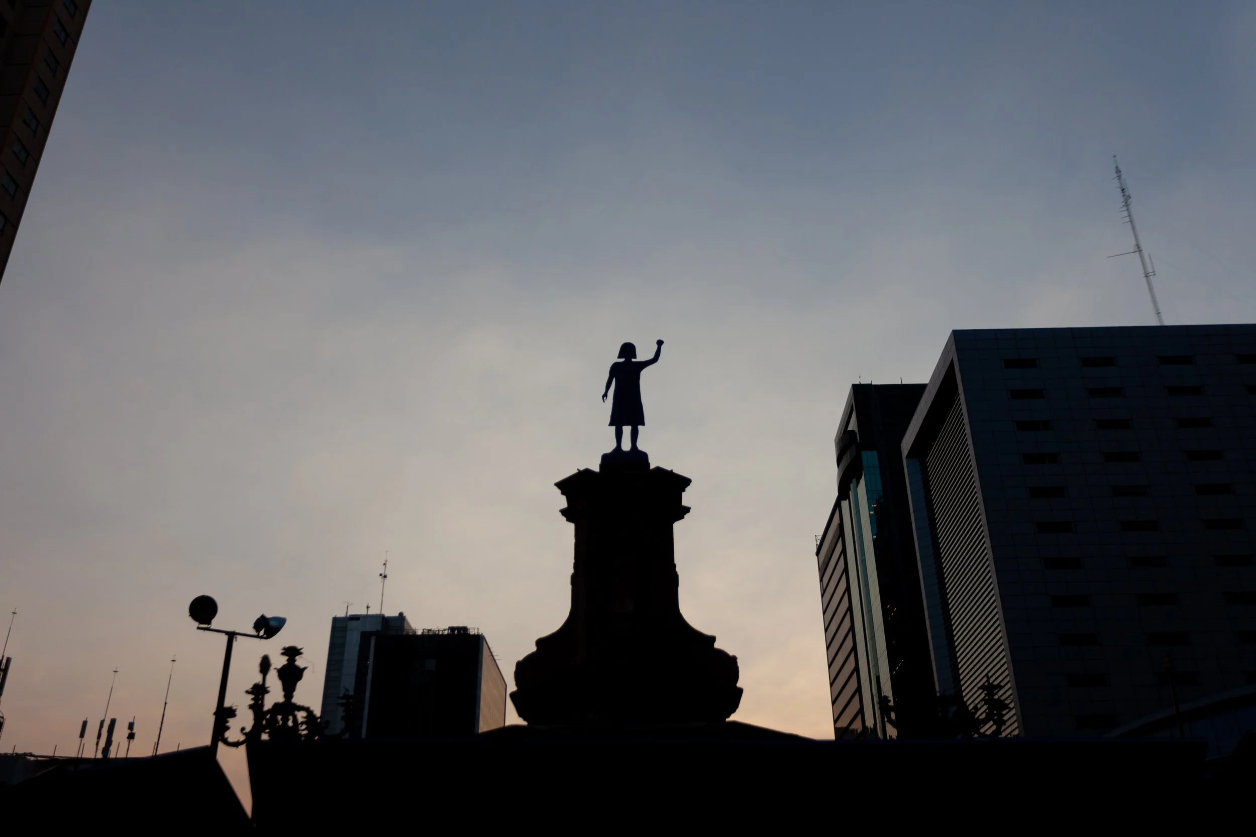 Statue of a girl with her fist raised in the air