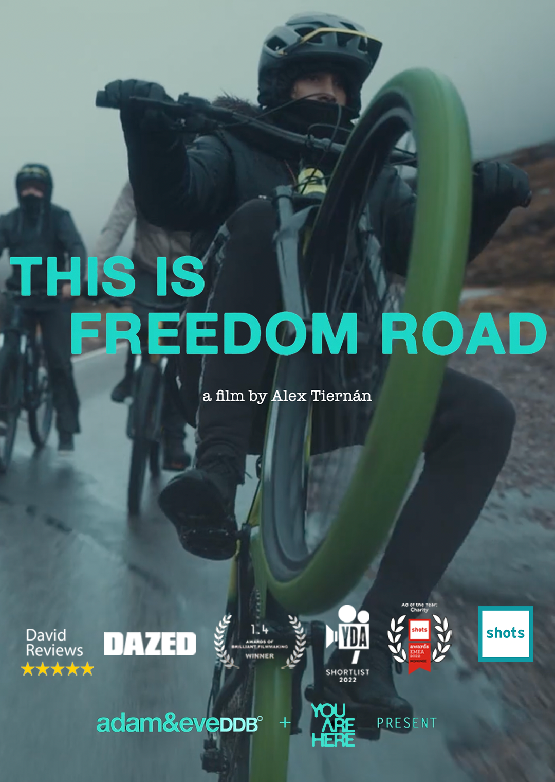 People riding bikes on a road in a documentary film poster titled 'This is Freedom Road' by Alex Tiernán, featuring awards and reviews.