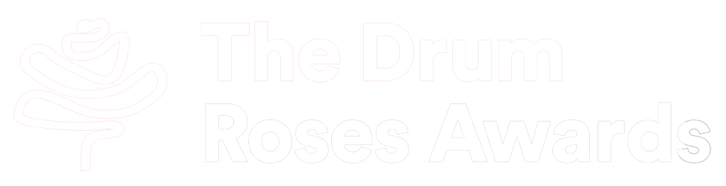 Logo for The Drum Roses Awards featuring a stylized white rose on a black background with the text 'The Drum Roses Awards'.