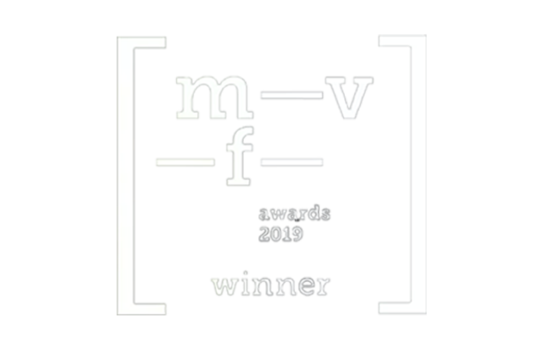 An award graphic with overlapping gray and white text that reads "mf-v awards 2019 winner" in a distorted and abstract style.