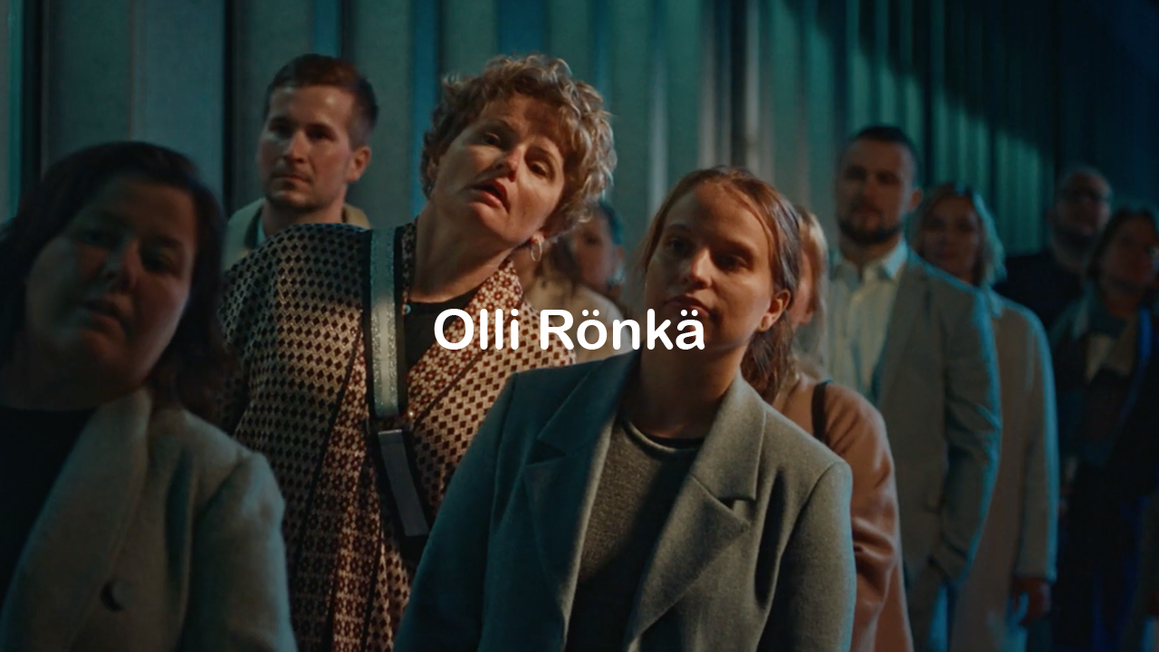 People attending a movie premiere or event, standing in front of teal curtains.