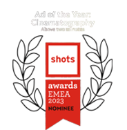 Graphic featuring an award badge with laurel branches, indicating a nomination for 'Ad of the Year' in Photography, with additional text about shots and awards, EMEA 2023.
