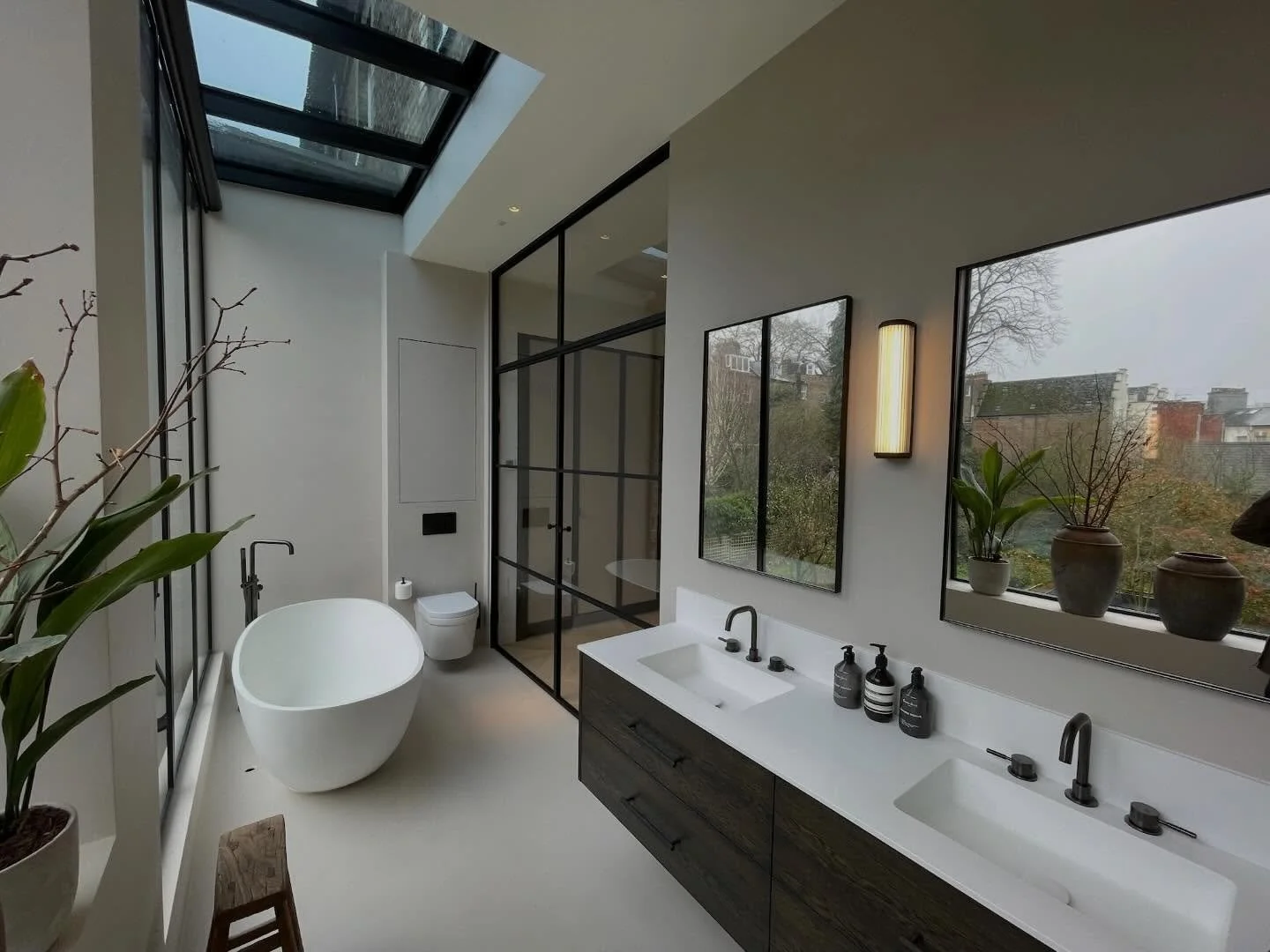 Natural light was central to the design of this master en suite bathroom.
Full-height glazing and overhead skylights draw daylight deep into the space, creating a calm, open atmosphere from morning through to evening. The freestanding bath sits benea