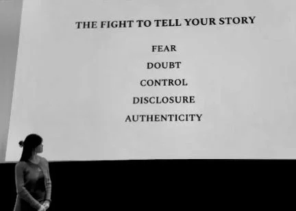 Carys Mei presenting at the Emerson College premiere of her intimate coming-of-age documentary “Home,” 2024. She is in front of a large projector screen that reads: "The Fight to Tell Your Story," Fear, Doubt, Control, Disclosure, Authenticity
