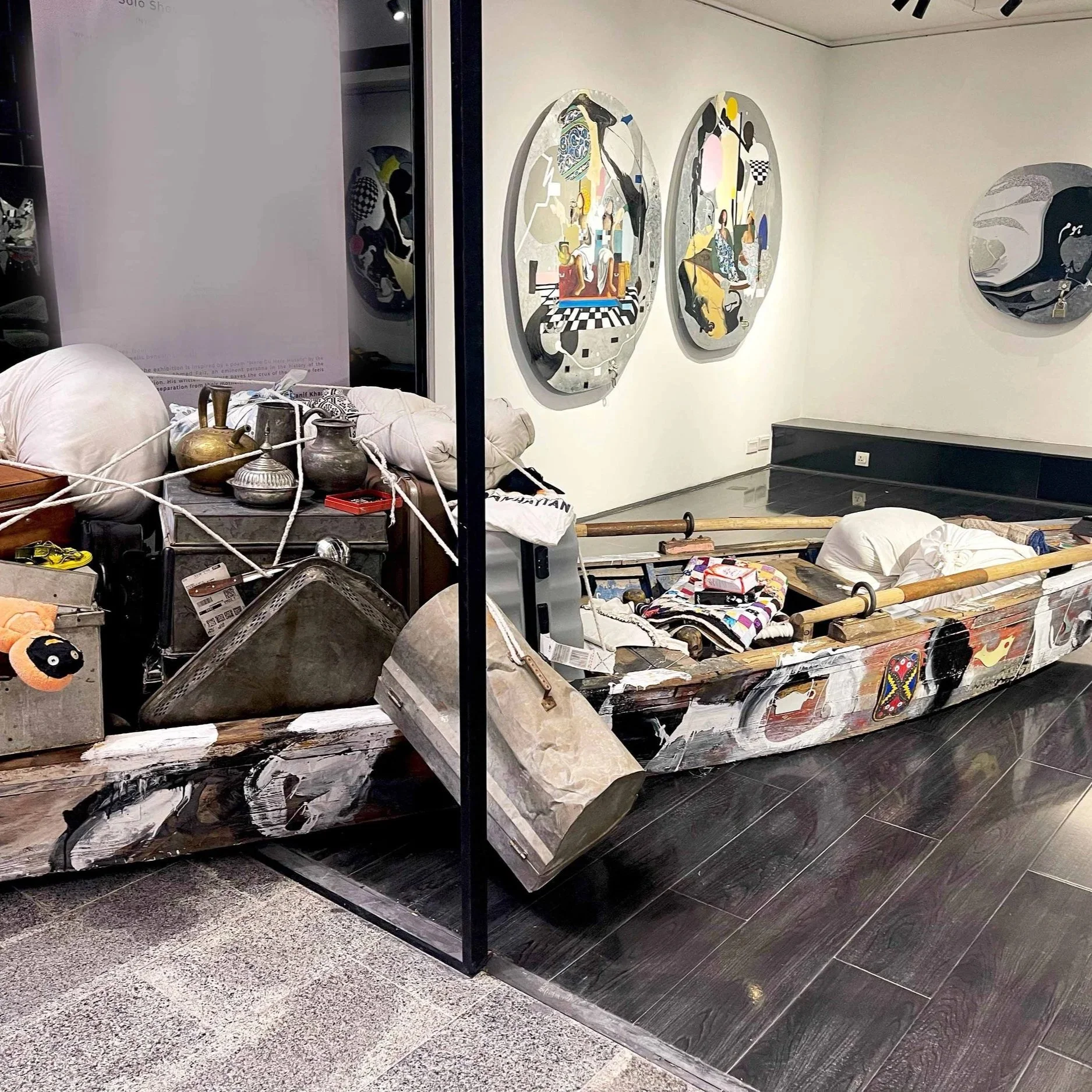 Chal Bulleya Authae Chaliye, The Good Immigrant I 15'x4' ft I Installation, Wooden Boat, Peyti, South Asian Trunks and House Hold Stuff with Recordings of Immigrants individuals inside different objects I 2023