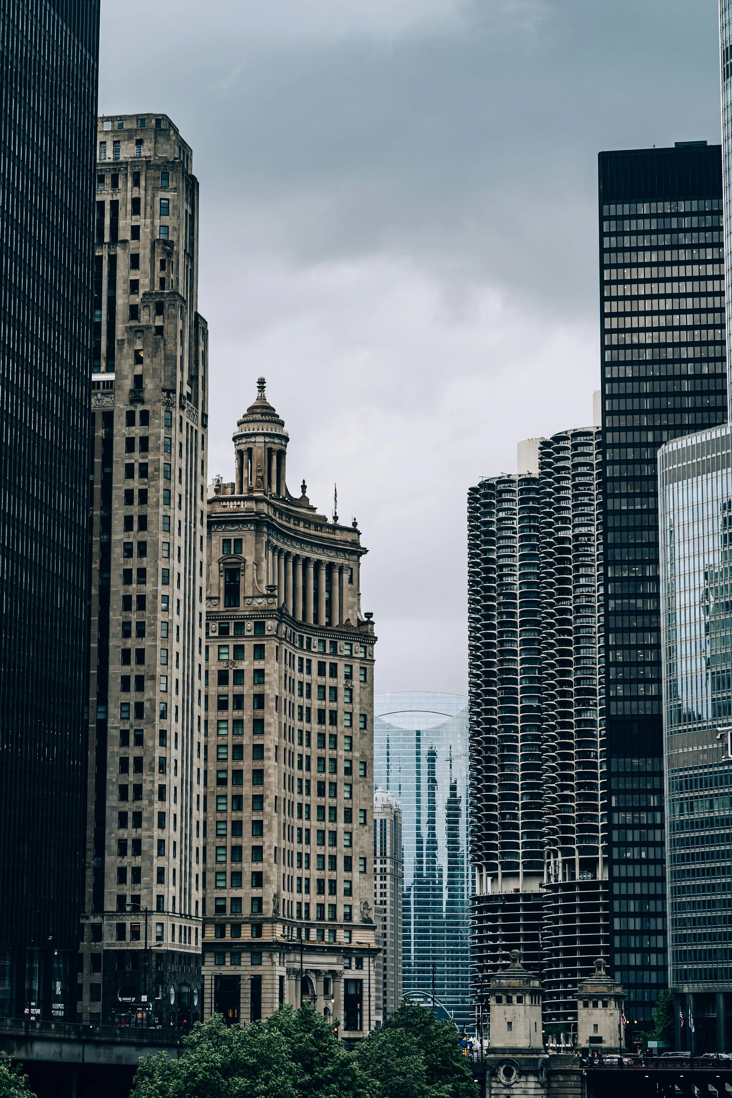 A cityscape of tall modern skyscrapers and historic buildings in downtown Chicago on a cloudy day.